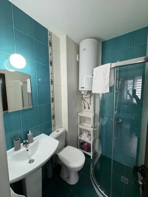 a bathroom with a toilet and a sink and a shower at La Mont Apartment Bansko in Bansko
