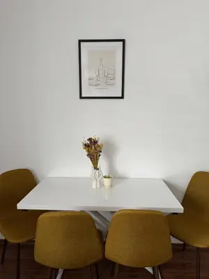 a white table with chairs and a vase of flowers at La Mont Apartment Bansko in Bansko