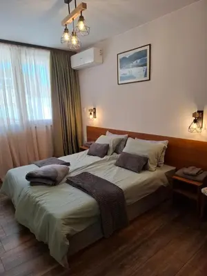 a bedroom with a large bed with pillows on it at Двуспален апартамент Милена в хотел Росица,Пампорово in Pamporovo
