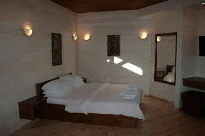 a bedroom with a bed with white sheets and a mirror at Tora Bora Guest House in Pancharevo