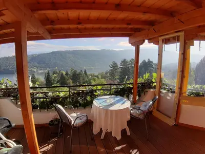 a table and chairs on a deck with a view at Tora Bora Guest House in Pancharevo