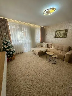 a living room with a couch and a christmas tree at Raya Apart Pamporovo in Pamporovo
