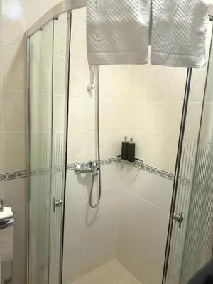 a shower with a glass door in a bathroom at Raya Apart Pamporovo in Pamporovo