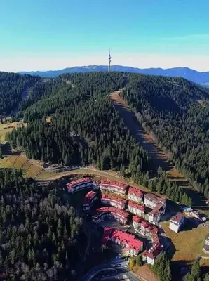 an aerial view of a forested area with red buildings at Viva 4-A-23 Apartment ski to the door complex Grand Monastery Pamporovo in Pamporovo