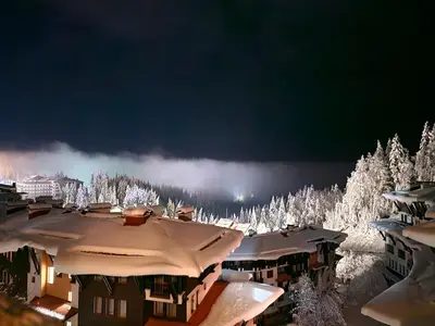 a snow covered town with snow covered trees and buildings at Viva 4-A-23 Apartment ski to the door complex Grand Monastery Pamporovo in Pamporovo