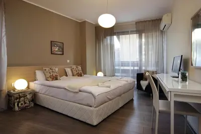 a bedroom with a large bed and a desk in it at Anita Guest House & Relax in Perushtitsa