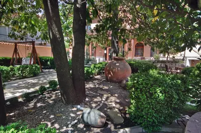 a large vase sitting on the ground under a tree at Anita Guest House & Relax in Perushtitsa