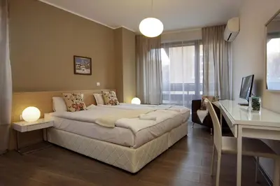 a bedroom with a large bed and a desk at Anita Guest House & Relax in Perushtitsa