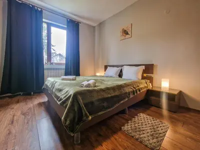 a bedroom with a bed with a dog laying on it at Charming Mont Blanc Bansko Apartment Near Ski Lift by Flat Mаnager in Bansko
