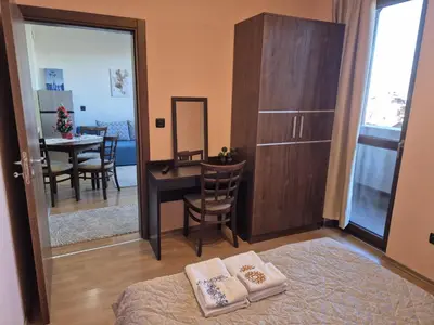a room with a bed and a desk and a mirror at Ski Lift Apartment - FORTUNA in Bansko