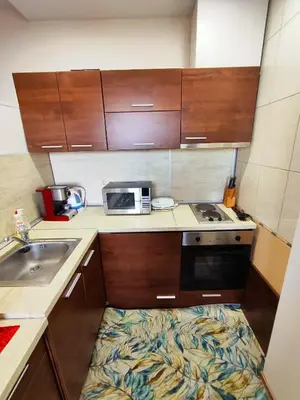 a small kitchen with a sink and a microwave at Ski Lift Apartment - FORTUNA in Bansko