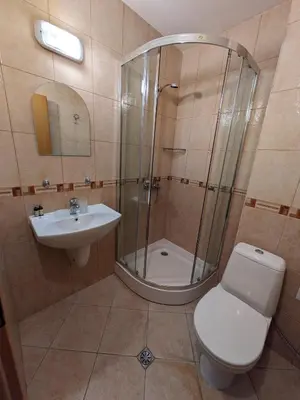 a bathroom with a shower and a toilet and a sink at Bansko holiday apartments - Mountain View Resort in Bansko