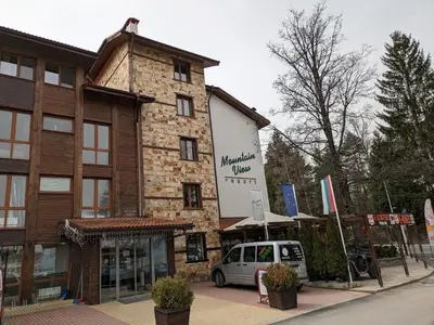a building with a car parked in front of it at Bansko holiday apartments - Mountain View Resort in Bansko