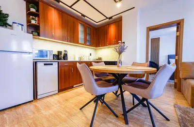 a kitchen with a table and chairs and a refrigerator at Yeti Apartment Pamporovo Grand Monastery in Pamporovo