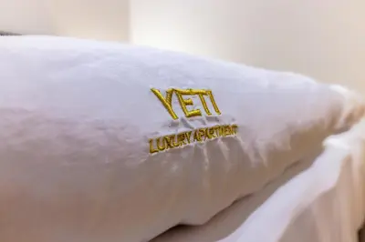 a pillow on a bed with aigil on it at Yeti Apartment Pamporovo Grand Monastery in Pamporovo