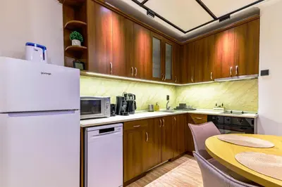 a kitchen with a table and a white refrigerator at Yeti Apartment Pamporovo Grand Monastery in Pamporovo
