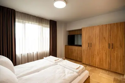 a bedroom with a bed and a flat screen tv at Къщи за гости ПАВЛЕВСКИ in Banya