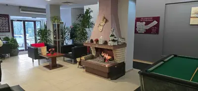 a lobby with a fireplace and a pool table at Forest Dreams in Pamporovo