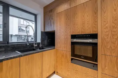 a kitchen with wooden cabinets and a sink and an oven at Luxurious House in an Exclusive Complex, Mount View in Sofia