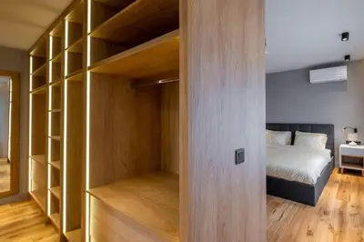 a bedroom with a bed and a closet with wooden shelves at Luxurious House in an Exclusive Complex, Mount View in Sofia