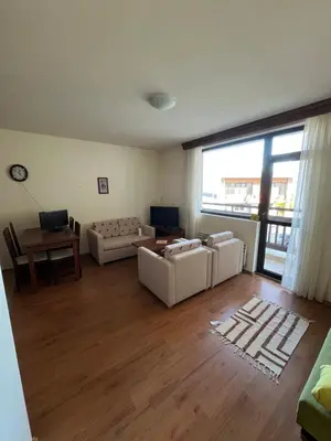 a living room with two couches and a table at Edelweiss Apartment in Bansko