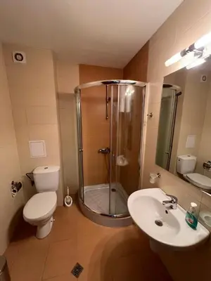 a bathroom with a shower and a toilet and a sink at Edelweiss Apartment in Bansko