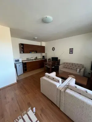 a living room with two couches and a kitchen at Edelweiss Apartment in Bansko