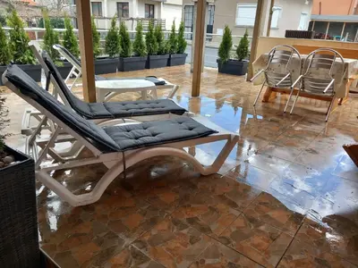 a chair and a table and chairs on a patio at ViBo Guesthouse in Sapareva Banya
