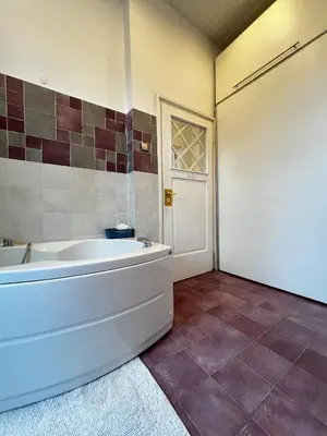 a large bathroom with a tub and a door at Christine's Apartment in Sofia