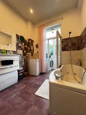 a large bathroom with a tub and a kitchen at Christine's Apartment in Sofia