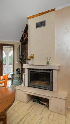 a living room with a fireplace and a table at Penthouse Astralis - Pamporovo in Pamporovo