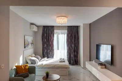 a living room with a bed and a tv at Luxury Studios in Top Center in Sofia