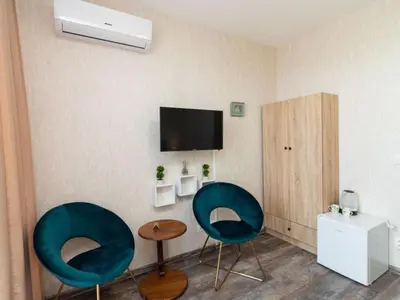 a room with two chairs and a tv on the wall at MezonetCentre in Sofia