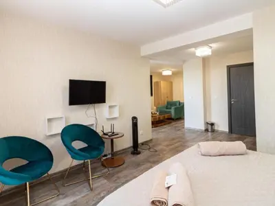 a bedroom with a bed and two chairs and a tv at MezonetCentre in Sofia