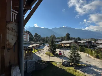 a view of a town with mountains in the background at Pirin Golf SP Apartments in Razlog