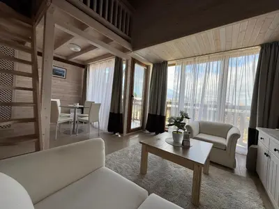 a living room with a couch and a table at Pirin Golf SP Apartments in Razlog
