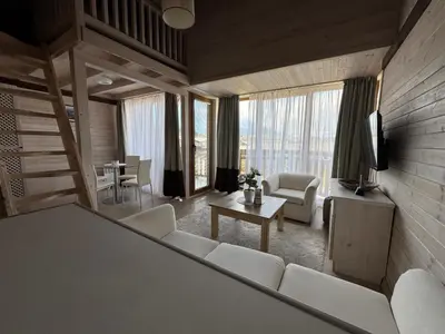 a living room with white furniture and a television at Pirin Golf SP Apartments in Razlog