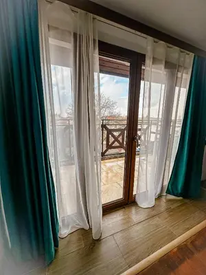 a room with a window with blue and white curtains at Banderitsa Hotel and Casino in Bansko