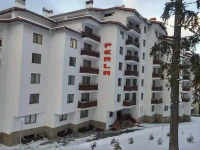 a large white building with a hotel sign on it at Уютен апартамент за зимна почивка в Пампорово in Pamporovo