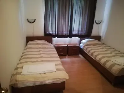 two beds in a small room with a window at Уютен апартамент за зимна почивка в Пампорово in Pamporovo