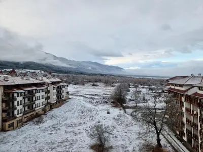 a snow covered city with buildings and a river at Belvedere private apartment 1-bedroom with balcony in Bansko