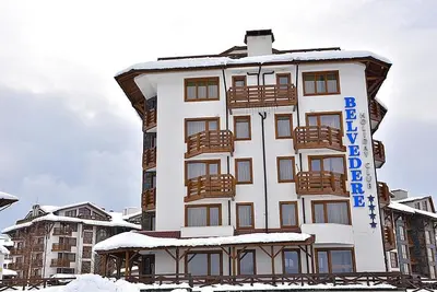 a large building with snow on top of it at Belvedere private apartment 1-bedroom with balcony in Bansko