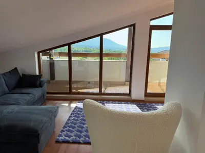 a living room with a couch and chairs and a large window at Belvedere private apartment 1-bedroom with balcony in Bansko