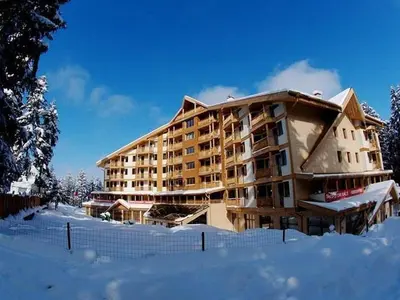 a large apartment building in the snow with a fence at Ski Studio Hotel Iceberg in Borovets
