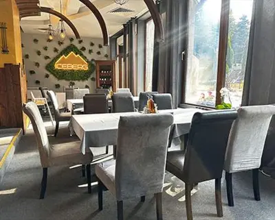 a dining room with a white table and chairs at Ski Studio Hotel Iceberg in Borovets