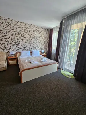 a bedroom with a bed and a large window at Ski Studio Hotel Iceberg in Borovets