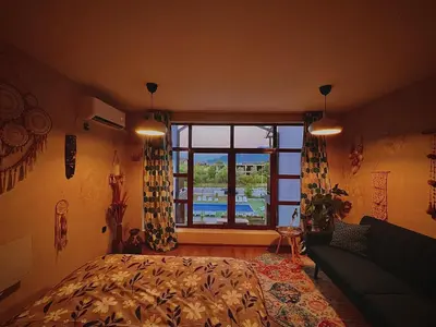 a bedroom with a bed and a large window at CozyHomes in Bansko
