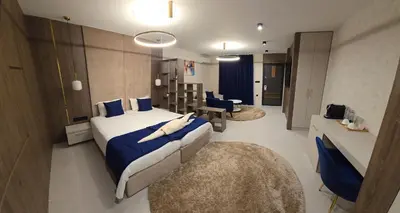 a hotel room with a large bed with blue sheets at Луксозни делукс стаи Мечката in Botevgrad