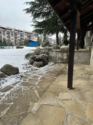 a stone walk way with snow on the ground at MonarX Suites 1113 in Bansko