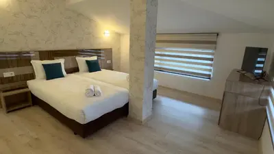 a bedroom with a bed with two white shoes on it at Семеен хотел БОНЖУР in Panagyurishte